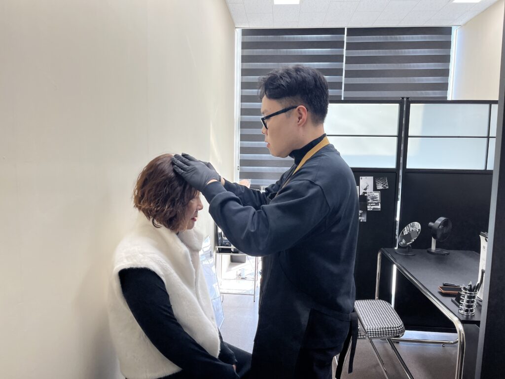 시술 전 두상과 모발 흐름을 직접 살펴보는 상담 장면