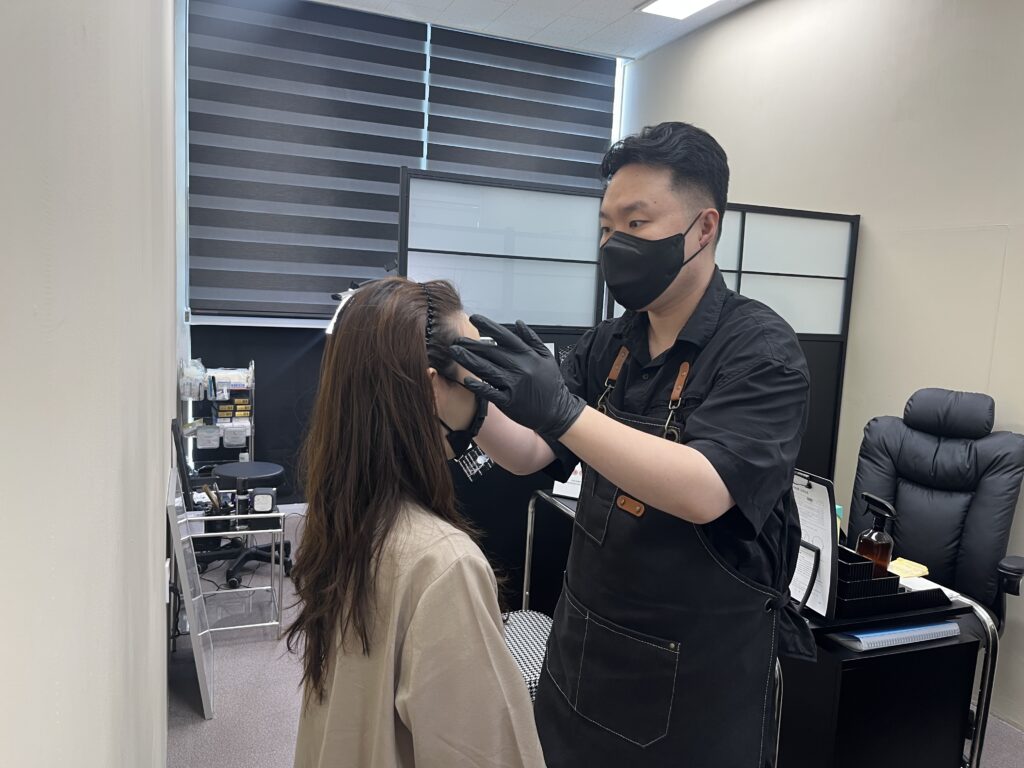 두피 상태를 직접 확인하며 시술 범위를 상담하는 모습