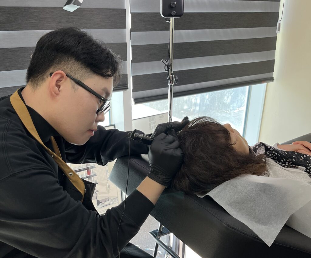 옆으로 누운 자세에서 두피 상태를 살피며 진행하는 시술