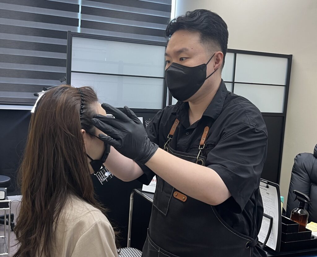 원장이 고객의 헤어라인 상태를 직접 확인하는 모습